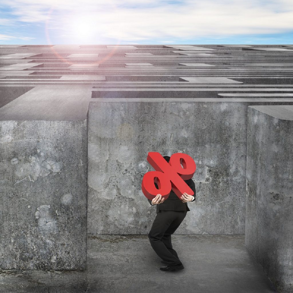 Man carrying big 3D red percentage sign entering the huge maze with blue sky clouds background